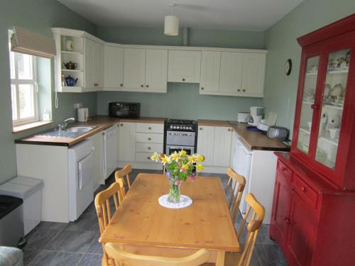 肯梅尔Feirm Cottage的厨房配有一张桌子,上面放着花瓶
