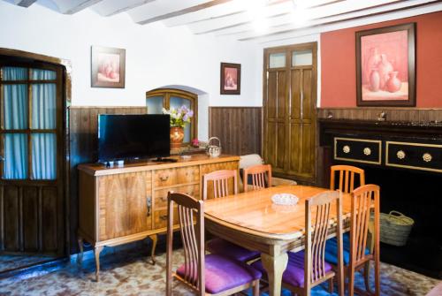 塞古拉 - 德拉谢拉Casa Felix的一间带木桌和椅子的用餐室