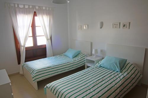普拉亚布兰卡Apartamento Villa Laura的小型客房 - 带2张床和窗户