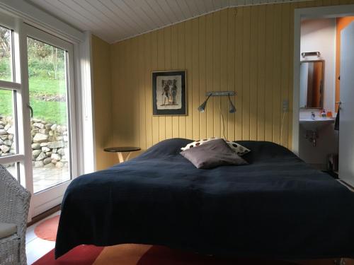 尼克宾摩斯Heltoften Bed & Breakfast的一间带一张大床的卧室,位于带窗户的房间内