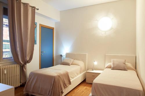 维罗纳Maison de Amelie的一间卧室设有两张床和窗户。