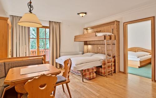 格罗萨尔Appartementhaus Alpenpark的一间卧室设有两张双层床和一张桌子
