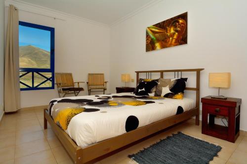 普拉亚布兰卡Villa Pura Vida的一间卧室设有一张大床和一个窗户。