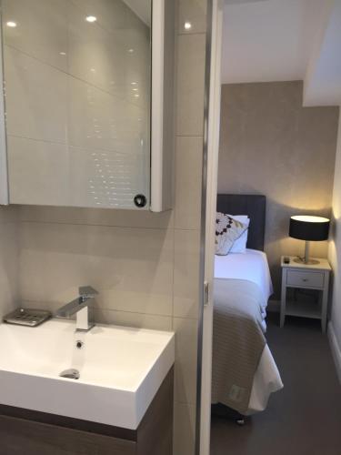 伦敦Modern 2 Bedroom Flat with private outdoor terrace的一间带水槽和床的浴室