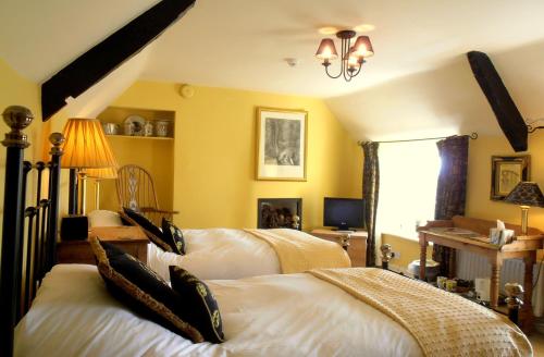 Clutton猎人休息酒店的一间卧室配有两张床和吊灯。