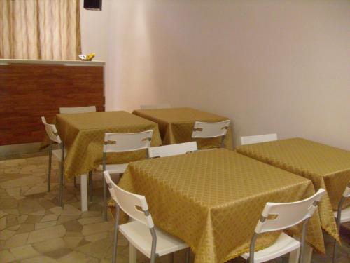米兰欧洲住宿加早餐酒店的一间设有两张桌子和椅子的房间,配有黄色的桌布