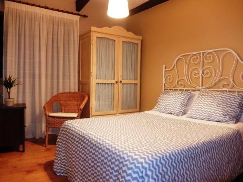 利亚内斯卡萨科提鲁别墅的一间卧室配有一张带蓝白色毯子的床