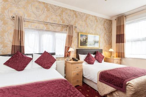 伦敦玫瑰景色亚历山德拉宫酒店的酒店客房,设有两张床和窗帘