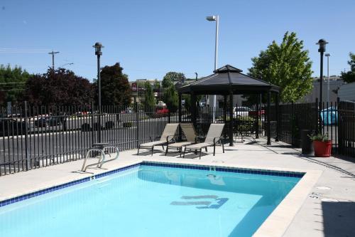 刘易斯顿路易斯顿美国旅馆的一个带两把椅子和遮阳伞的游泳池