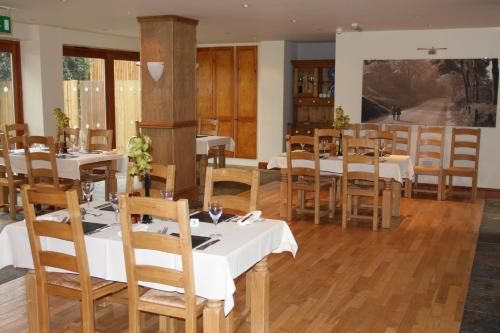 皮克林坦塔拉乡村酒店的餐厅设有白色的桌子和木椅