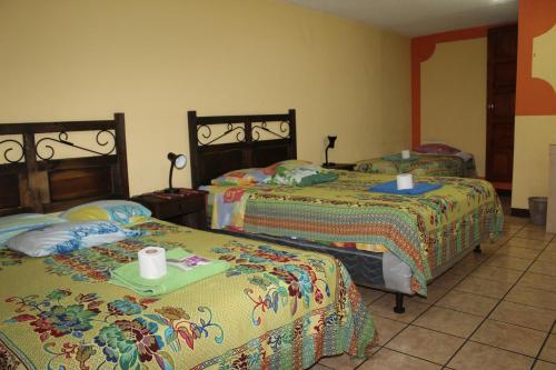 克萨尔特南戈Hotel Kasa Kamelot的一间卧室配有两张床和两张桌子