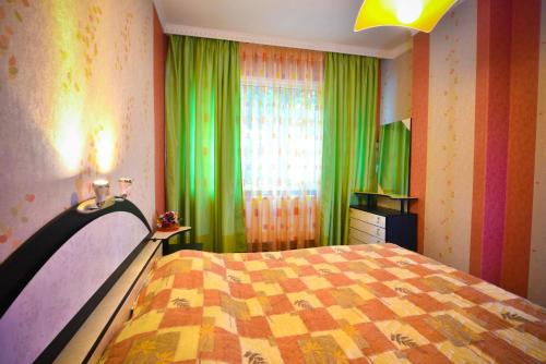 旧扎戈拉Apartment Elegance的一间卧室设有床铺和一个带绿色窗帘的窗户。