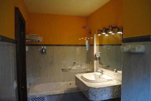 Peñamellera Alta朱利安酒店的一间带水槽、浴缸和镜子的浴室