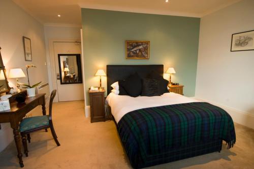 泰纳布鲁厄赫皇家小湖酒店的一间卧室配有一张床、一张书桌和一张书桌