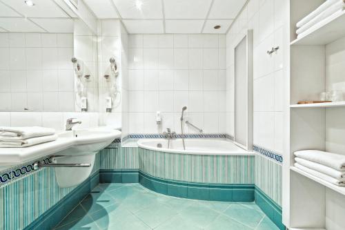 卢布林维多利亚酒店的白色的浴室设有浴缸和水槽。