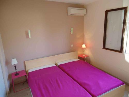 贝济耶Delaporte的一间卧室配有一张带紫色床单的大床