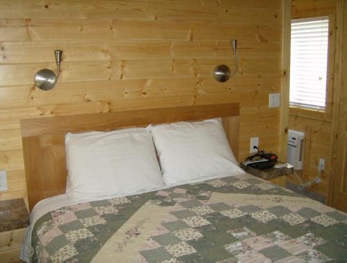 NicolausLake Minden Camping Resort Cottage 2的一间卧室配有一张木墙床