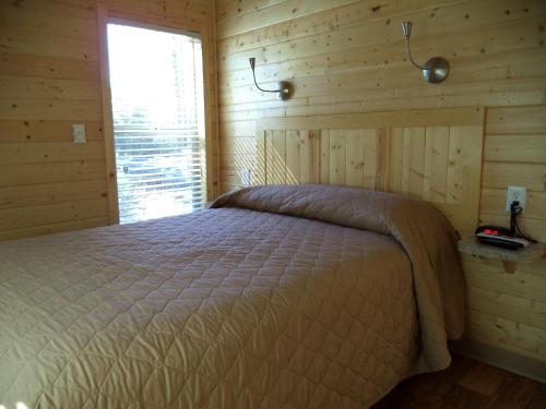 棕榈荒漠Palm Springs Camping Resort Cabin 3的木制客房内的一间卧室,配有一张床