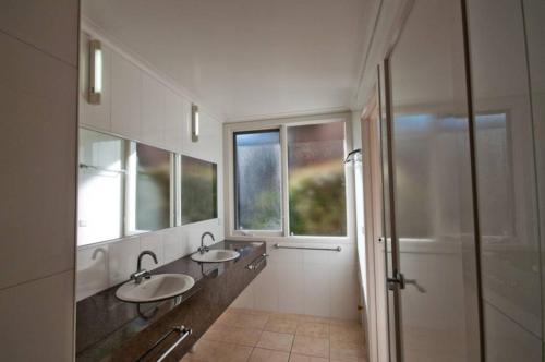 Lake TyersPelicans Perch的浴室配有2个盥洗盆和步入式淋浴间。