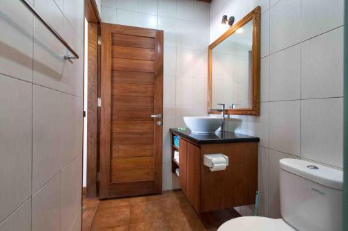 蓝梦岛Kainalu Beach House的一间带水槽、卫生间和镜子的浴室