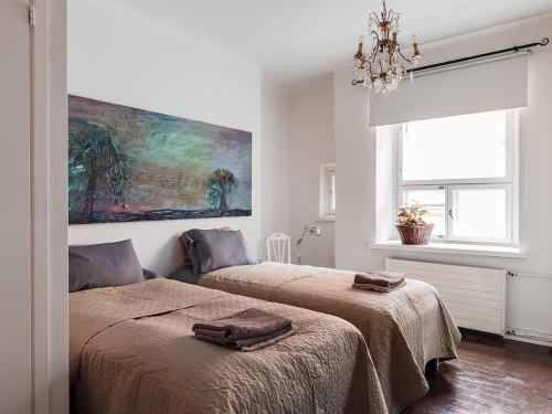 赫尔辛基Artist Apartment Susi的一间卧室设有两张床,墙上挂着一幅画