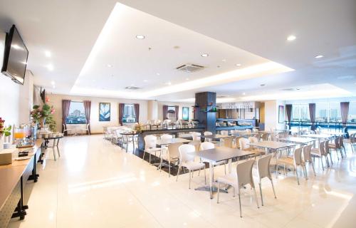 雅加达Hotel 88 - Mangga Besar VIII Jakarta By WH的一间带桌椅的餐厅和一间酒吧