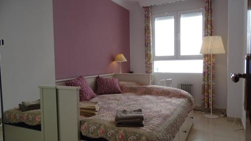 加的斯Cosy Caleta Apartment的一间小卧室,配有床和窗户