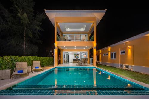 象岛Sunset Emily Villas & Rooms的一座晚上设有游泳池的房子