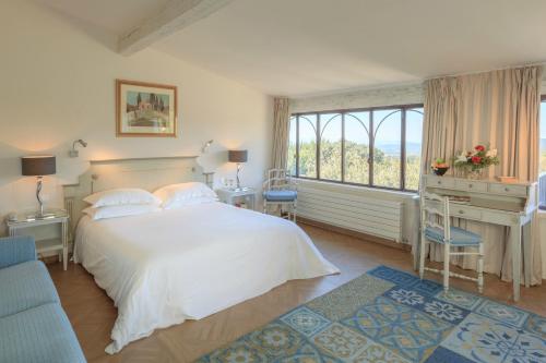 戈尔德戈尔德乐雅酒店 的一间卧室配有一张床、一张书桌和一个窗户。