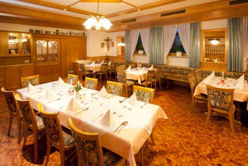 HohenauLandhotel-Gasthof-Schreiner的一间设有白色桌椅的用餐室