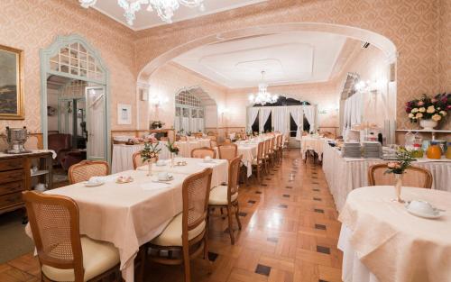 斯特雷萨杜帕克酒店的用餐室配有带白色桌布的桌子