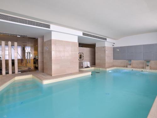佩鲁贾珊伽洛宫殿酒店的大楼里的一个大型蓝色游泳池