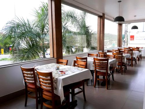 瓦拉达里斯州长市普拉纳尔托2号酒店的餐厅设有桌椅和大窗户。