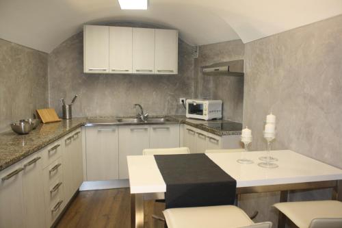 贝萨卢Cal Arxè的厨房配有白色橱柜和桌椅