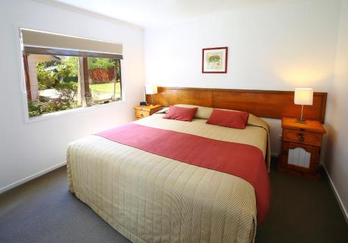 彭特派因Poinciana Cottages的一间卧室设有一张大床和一个窗户。