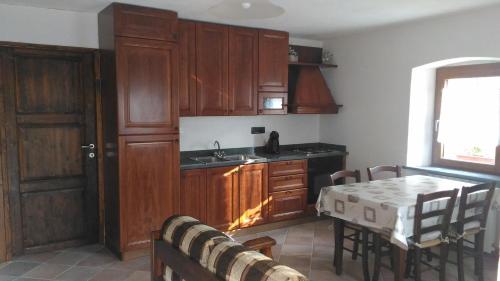 蓬圣马丁Maison Bellevue VDA-PERLOZ-N 0001的厨房配有木制橱柜、桌子和水槽。