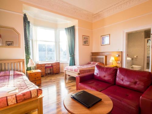 爱丁堡科斯托芬妮旅馆酒店的客厅配有红色的沙发和床。