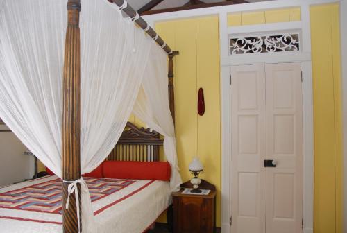 温沃德赛德House On The Path的一间卧室设有天蓬床和白色门