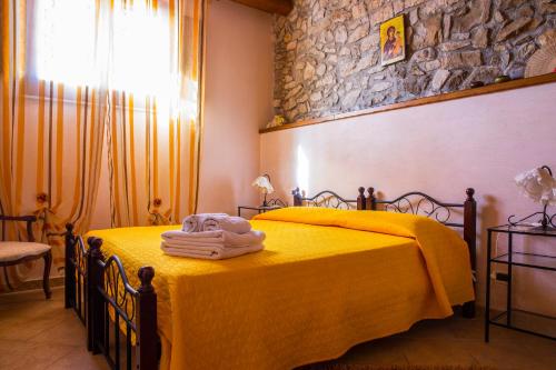 CaccamoCasa Vacanze Caccamo Santa Lucia的一间卧室配有黄色的床和毛巾