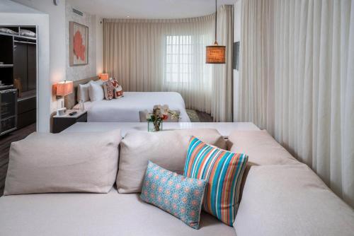 迈阿密海滩马林酒店的客厅配有两张床和一张带枕头的沙发。