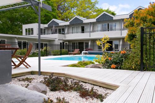 陶波Anchorage Resort Taupo NZ的庭院中带游泳池的房子