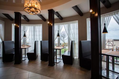 泽列诺格拉茨克Hotel Zolotaya Milya的用餐室设有桌椅和窗户。