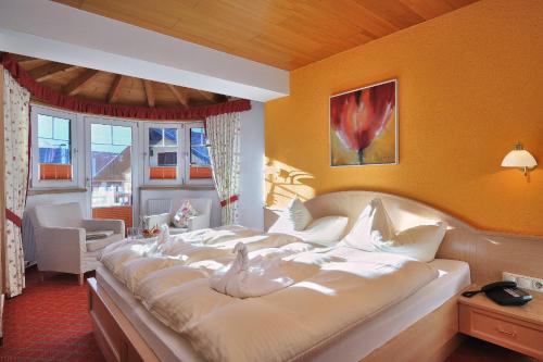 罗伊特Die Lilie / Hotel Garni的一间卧室配有一张大床,上面有鸟儿