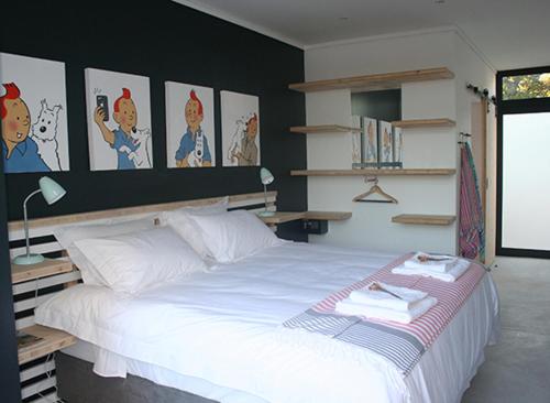 开普敦No. 9 Keurboom的卧室配有一张大白色床,墙上挂有图片