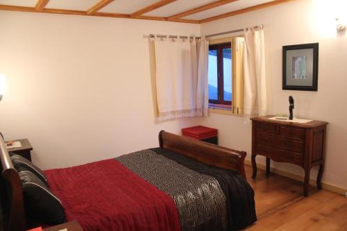 雷森迪Casa de Tapadeiro的一间卧室配有一张床、一个梳妆台和一扇窗户。