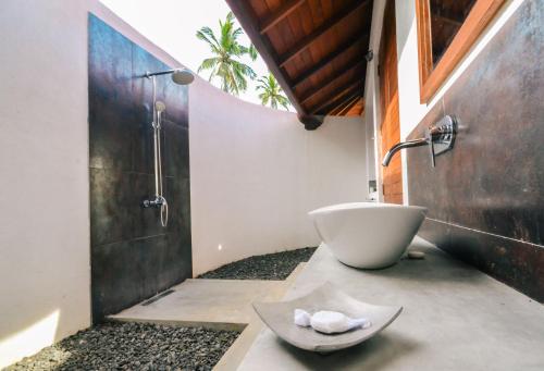 坦加拉桑吉士海边小屋的浴室配有盥洗盆和浴缸。