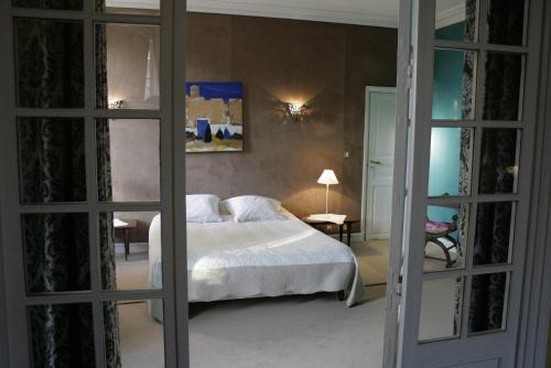 里贝拉克chambres de charme "Florence"的卧室配有白色的床和镜子