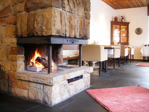 伊本比伦哈勃特斯诺夫酒店的用餐室设有石制壁炉,配有桌子
