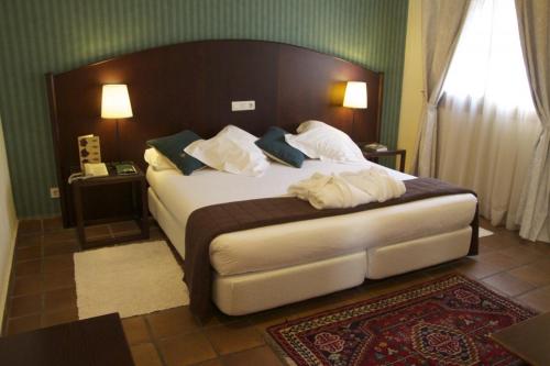 波凯兰特勒希塔西奥酒店的卧室配有一张带白色床单和枕头的大床。