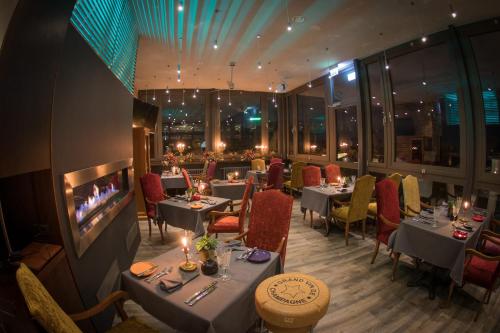 里加古腾堡酒店的一间带桌椅和壁炉的餐厅